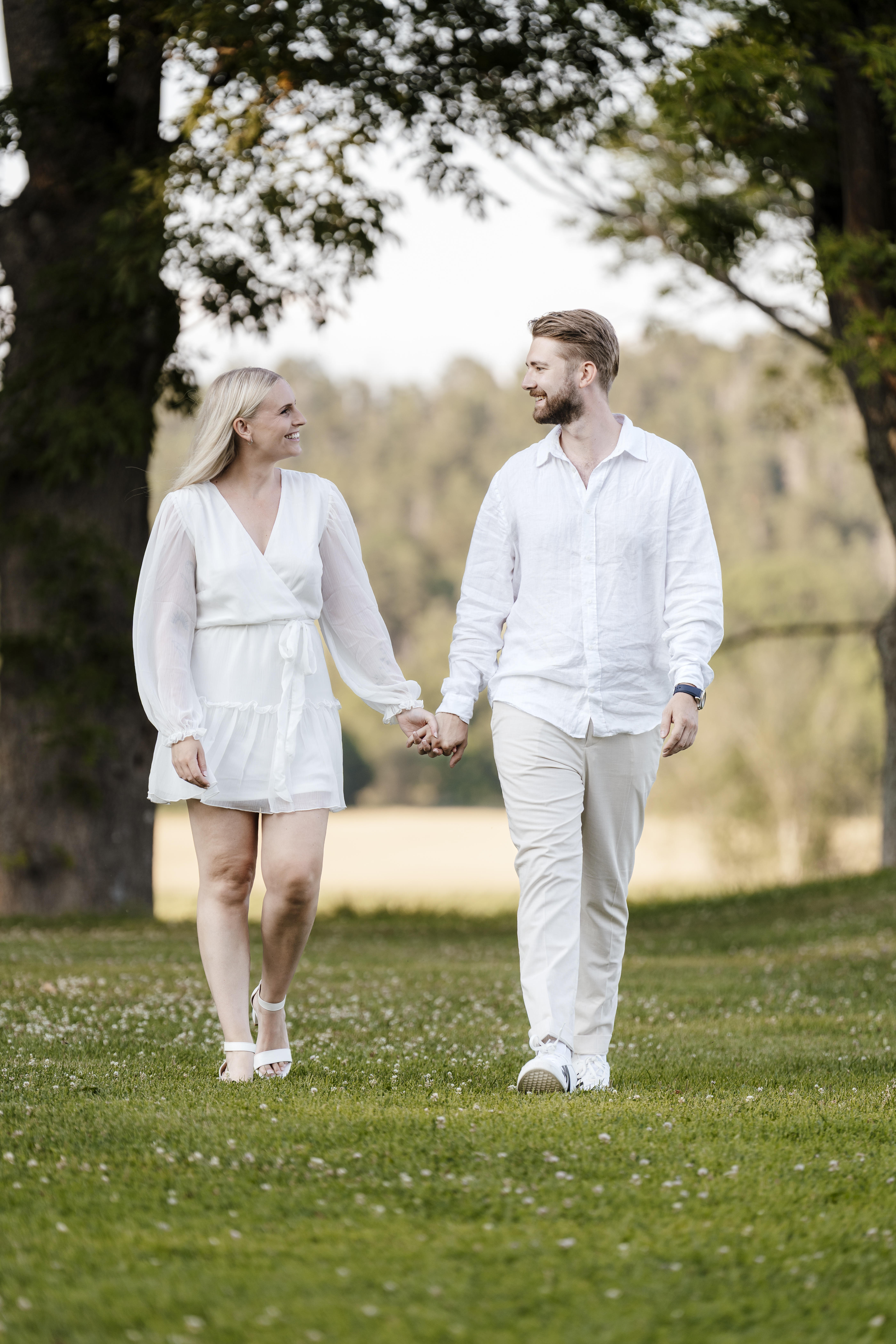 Par som holder hender i parken